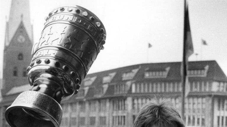 Abwehrspieler Manfred Kaltz hält den eroberten DFB-Pokal auf dem Balkon des Hamburger Rathauses in die Höhe.