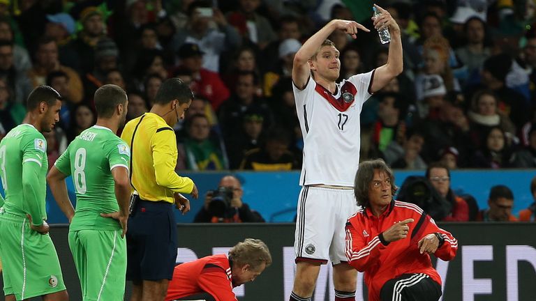 30.06.2014: Shkodran Mustafi bleibt im WM-Spiel gegen Algerien verletzt liegen, Müller-Wohlfahrt ist sofort zur Stelle. 