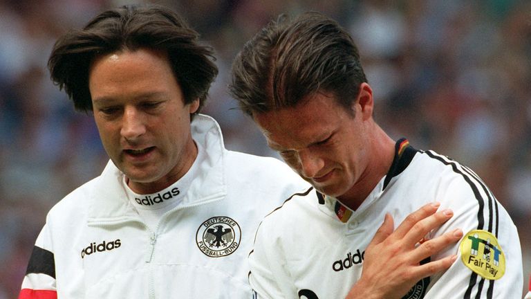 23.6.1996: Müller-Wohlfahrt begleitet den an der Schulter verletzten Fredi Bobic vom Feld.