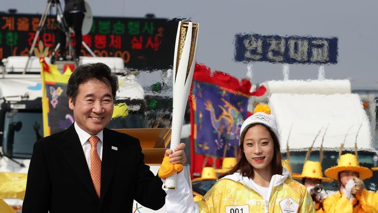 Der südkoreanische Premierminister Lee Nak-yon und Eiskunstläuferin You Young nehmen die Flamme in Empfang.