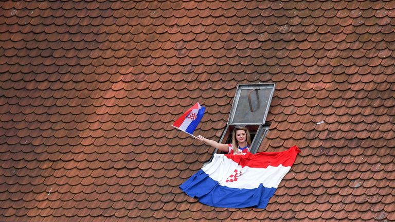 Jeder noch freie Platz wird in Zagreb genutzt - so wie diese Frau die Aussicht aus dem Dachfenster genießt; natürlich gesäumt von der kroatischen Flagge.