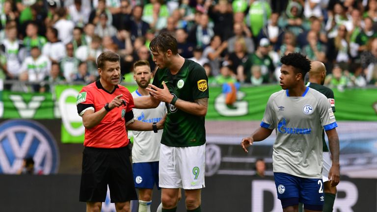 Wolfsburgs Wout Weghorst weigert sich nach einer vermeintlichen Tätlichkeit, den Platz zu verlassen. Mit Erfolg: Schiedsrichter Ittrich nimmt seine Entscheidung zurück.
