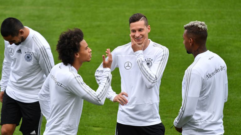 Julian Draxler flachst mit Leroy Sane (l.) und Jerome Boateng (r.).