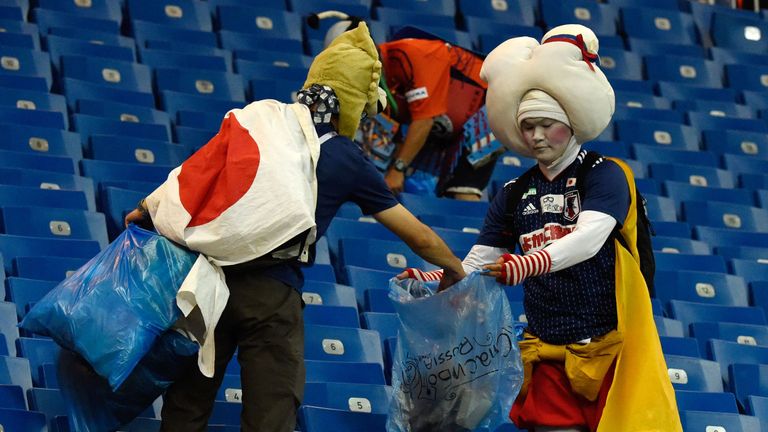 Die Japan-Fans räumen ihren Müll auf der Tribüne weg.