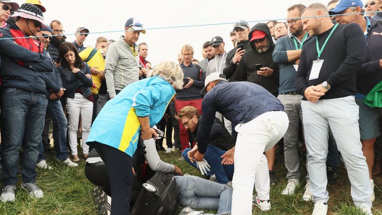 Eine Zuschauerin wird von Brooks Koepka am Kopf getroffen und bricht daraufhin verletzt zusammen. Der Golfprofi und andere eilen direkt zur Hilfe.