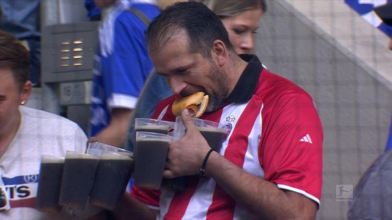Ein Fan von Fortuna Düsseldorf deckt sich mit Bier ein. Er trägt ein Trikot von Roter Stern Belgrad.