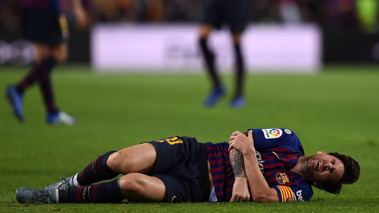 Mit schmerzverzerrtem Gesicht liegt Lionel Messi am Boden.