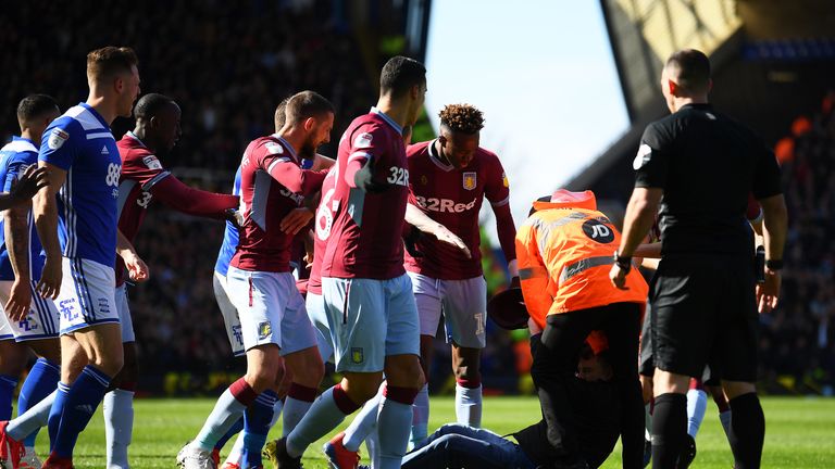 Ein Fan stürmt auf den Platz und attackiert den Kapitän von Aston Villa.
