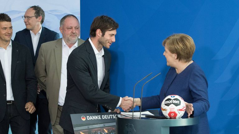 Kapitän Uwe Gensheimer überreicht beim Besuch in Berlin der Kanzlerin Angela Merkel ein Mannschaftsfoto.