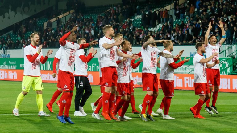 Die Spieler des 1. FC Köln tanzen in "Widder do!"-Shirts vor den freudetrunkenen Fans.