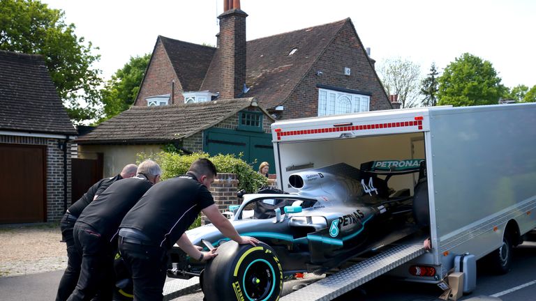 Mercedes-Mitarbeiten fahren den Formel-1-Wagen aus dem Laster. 