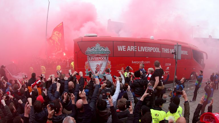 Der Bus des FC Liverpool fährt durch roten Pyro-Nebel. 