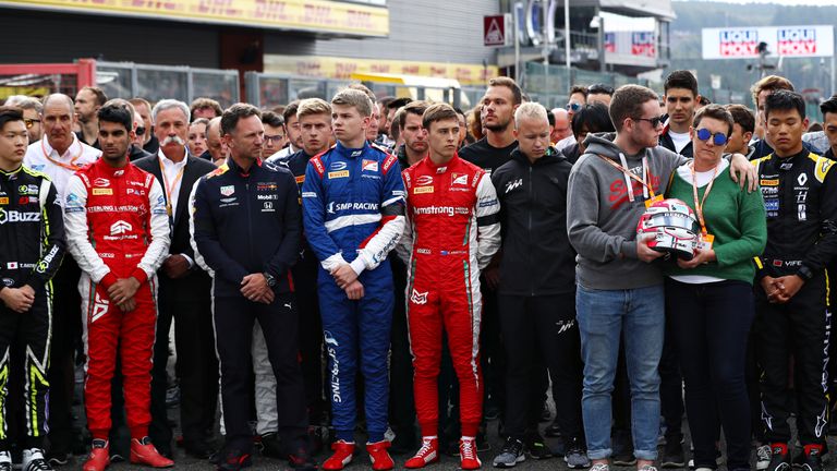 Anthione Huberts Mutter und sein Bruder halten während der ersten Schweigeminute den Helm des verunglückten Fahrers.