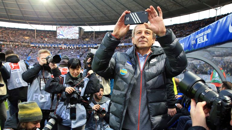 Während Klinsmann das Stadion fotografiert, machen die Fotografen Bilder von ihm.