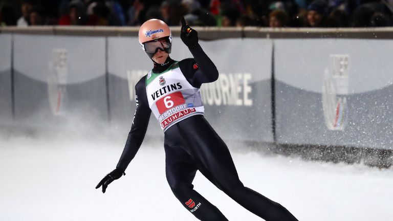 Karl Geiger springt auf das Podest. 