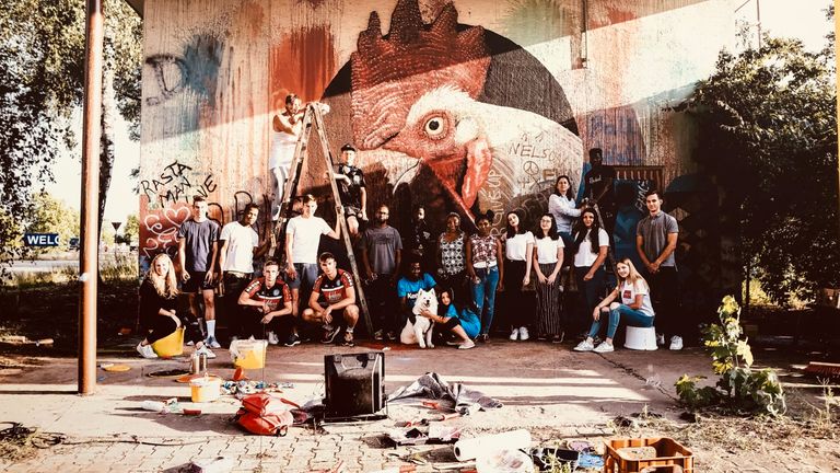 Die erste Aktion von "Ballwall" war ein Workshop mit Geflüchteten, jungen Handballern der HG Oftersheim Schwetzingen und mit Topstar Uwe Gensheimer. Gemeinsam mit dem Künstler Matthias Mross gestalteten sie im Juli eine Fassade in Heidelberg.