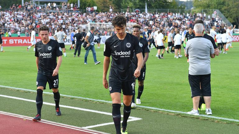 Bedrückte Gesichter beim Favoriten Frankfurt im Vordergrund - Feiernder Underdog Ulm im Hintergrund. 