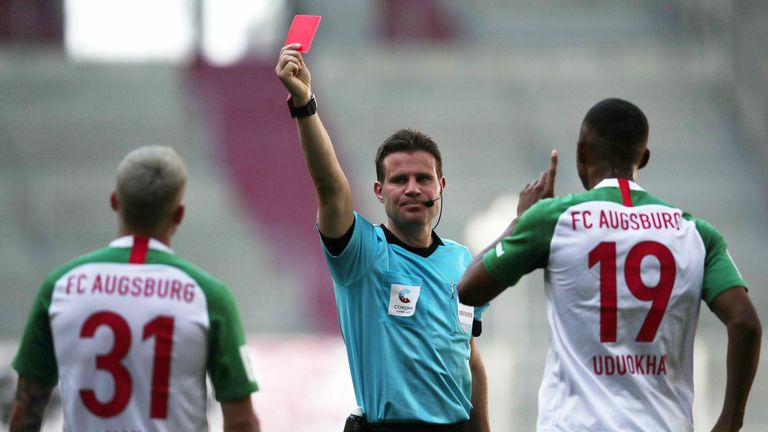 Schiedsrichter Felix Brych teilt eine Rote Karte aus.