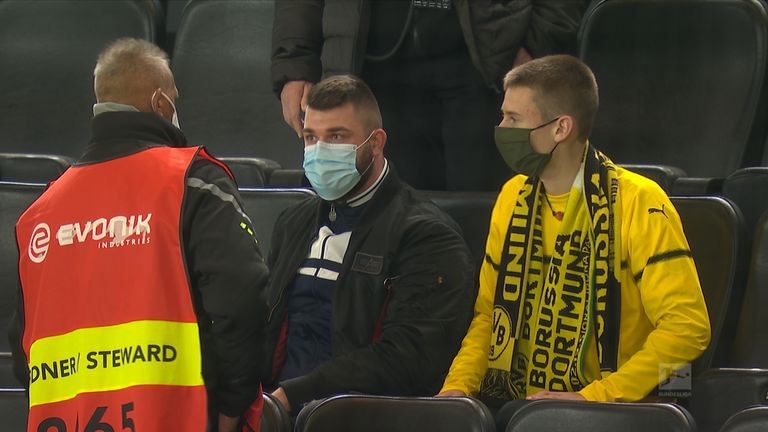 Der Schalke-Fan wird von einem Ordner angesprochen.