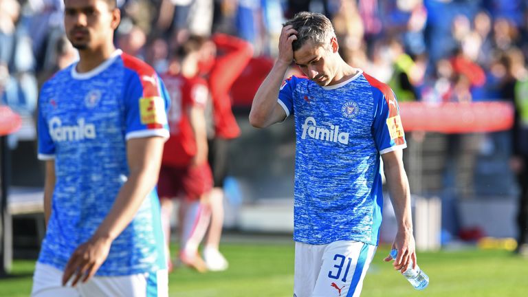 Finn Bartels (r.) verlässt nach der verlorenen Relegation mit gesenktem Kopf das Feld.