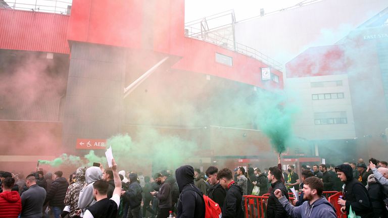 Fans make their way past barriers outside the ground as they let off flares whilst protesting against the Glazer family, owners of Manchester United, before their Premier League match against Liverpool at Old Trafford, Manchester. Issue date: Sunday May 2, 2021. PA Photo. See PA story SOCCER Man Utd. Photo credit should read: Barrington Coombs/PA Wire.