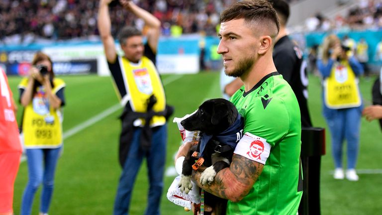 Schlussmann Deian Sorescu (Dinamo Bukarest) trägt einen Hund auf dem Arm zum Duell gegen FCSB.