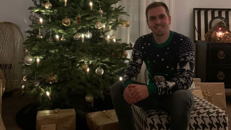 Richtig weihnachtlich ist's bei Philipp Lahm. Im klassischen Weihnachtspulli vor dem mit Geschenken ausgelegten Weihnachtsbaum sendet der Ex-DFB-Kapitän Grüße in die Welt (Quelle: Twitter/@philipplahm)