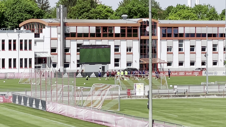 Auf den Trainingsgelände des FC Bayern ist eine riesige Videoleinwand eingezogen.