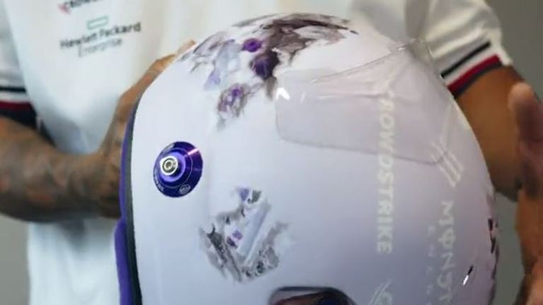 Lewis Hamilton präsentiert ein spezielles Helm-Design mit Kristallen. Der Helm ist hauptsächlich in lila gehalten.