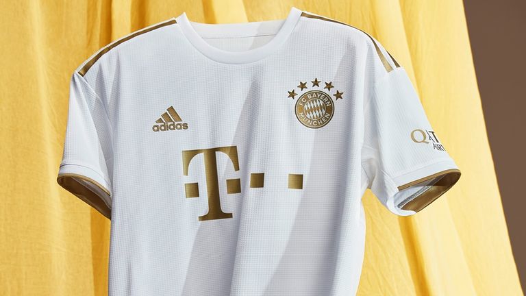 Das Trikot ist in weiß gehalten und mit goldenem Schriftzug und Emblem versehen (Bildquelle: FC Bayern München).