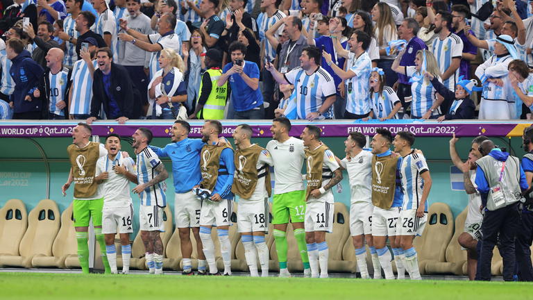 Die Bankspieler von Argentinien feiern und singen gemeinsam mit ihren Fans kurz vor Spielende im WM-Halbfinale gegen Kroatien.
