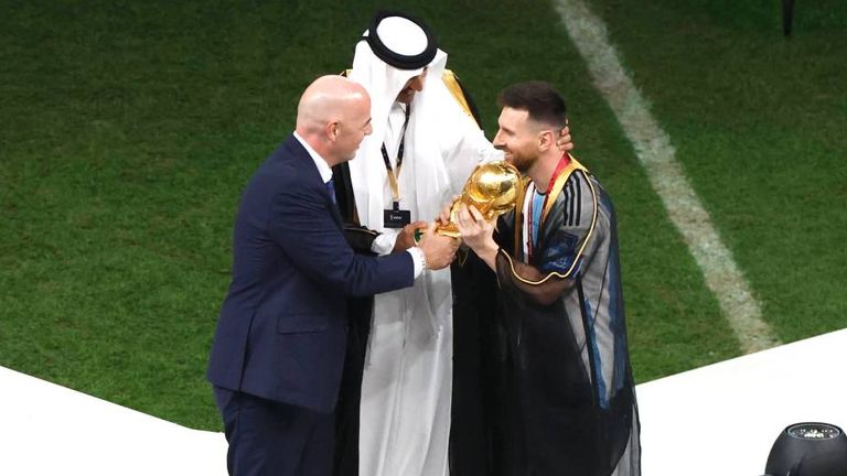 Lionel Messi bekam neben dem WM-Pokal auch ein arabisches Gewand umgehangen.