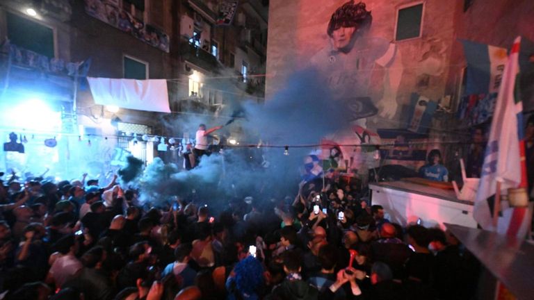 Im Stadtzentrum von Neapel feiern die Fans vor einer Fassade, auf der ein Bild des legendären Diego Maradona zu sehen ist.