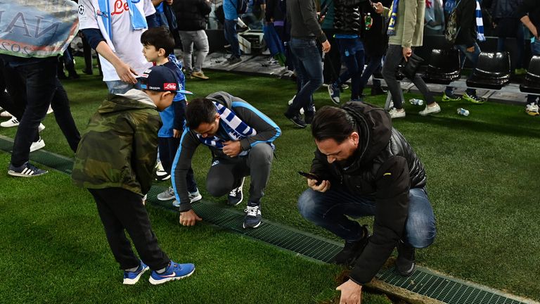 Napoli-Fans nehmen sich ein Stück des Rasens im Udinese-Stadion mit.