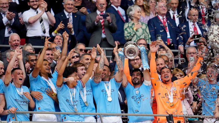 Manchester City&#39;s Ilkay Gundogan raises the trophy to celebrate with his team winning the English FA Cup final soccer match between Manchester City and Manchester United at Wembley Stadium in London, Saturday, June 3, 2023.(AP Photo/Jon Super)