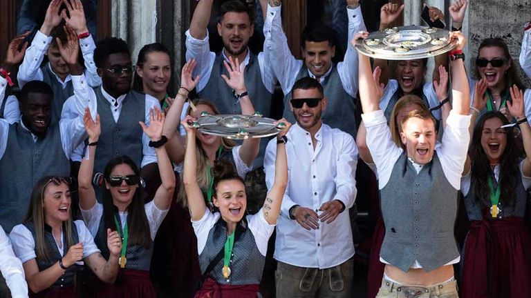 Lina Magull und Manuel Neuer halten auf dem Münchner Rathausbalkon die beiden Meisterschalen des FC Bayern in die Höhe.