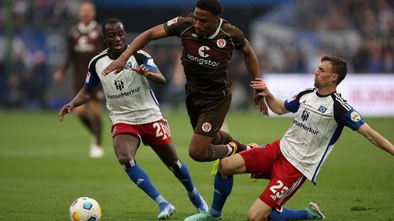 St. Paulis Oladapo Afolayan (M) im Duell mit den HSV-Akteuren Jean-Luc Dompe (l.) und Jonas Meffert.