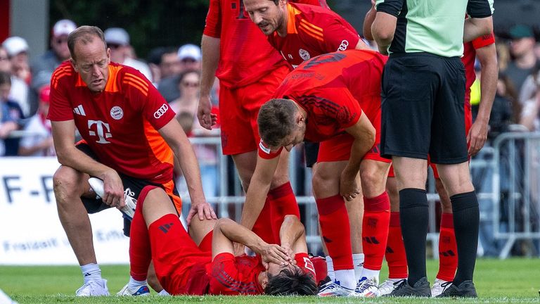 Bayern-Neuzugang Hiroki Ito hält am Boden vor Schmerzen die Händen vor dem Gesicht.