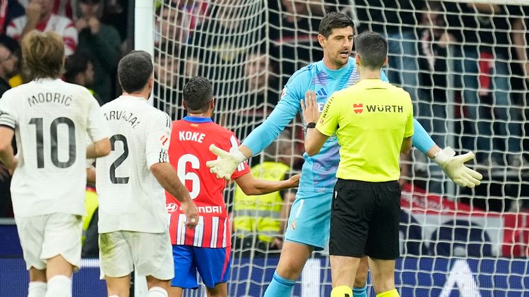 Real-Keeper Thibaut Courtois (2. von r.) spricht mit Schiedsrichter Mateo Busquets Ferrer.