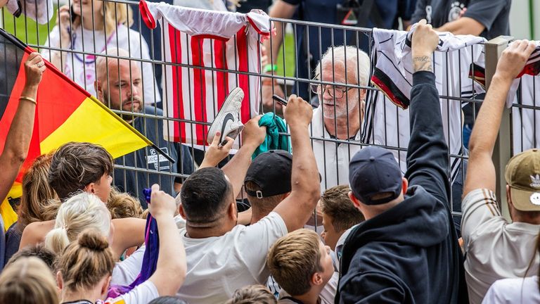 Die Fans wollen ein Autogramm von DFB-Sportdirektor Rudi Völler.