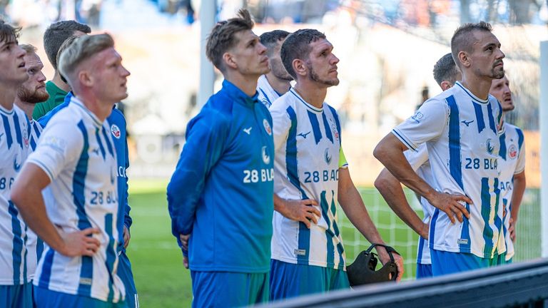 Die Spieler von Hansa Rostock stehen vor der eigenen Fankurve.