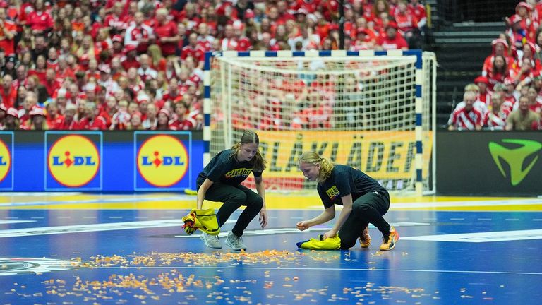 Helfer entfernen Konfetti, das ein Mann zuvor auf dem Spielfeld verstreut hatte.