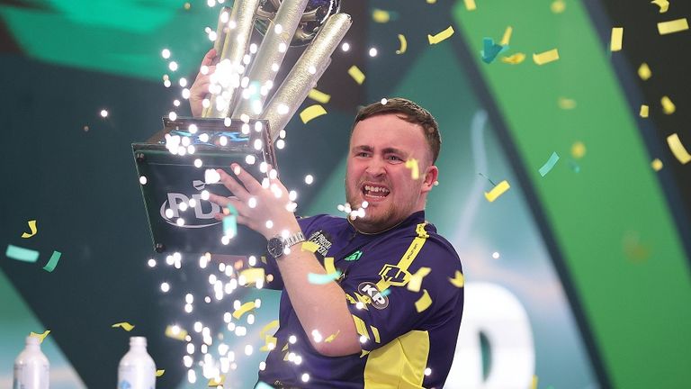 Darts-Wunderkind Luke Littler reckt die Sid-Waddell-Trophy in die Höhe.