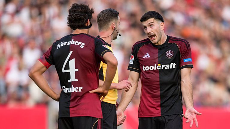 Nürnberg-Verteidiger Luka Lochoshvili (r.) diskutiert mit Schiedsrichter Michael Bacher.