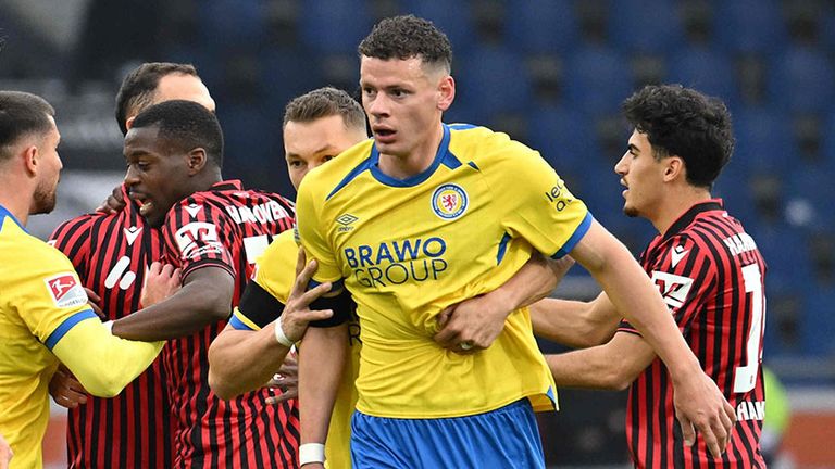 Braunschweig-Stürmer Erencan Yardimci (M) muss zurückgehalten werden.