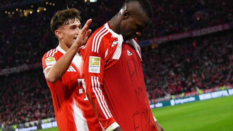 Bayern-Stürmer Nicolas Jackson (r.) mit Trauer-Gruß nach seinem ersten Tor in der Bundesliga.