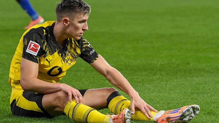 Nico Schlotterbeck sitzt hier in Hamburg auf dem Boden und hält sich sein Bein.