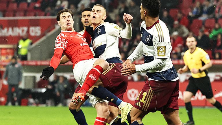 Mainz-Verteidiger Dominik Kohr (l.) erwischt HSV-Profi Miro Muheim (M) mit der offenen Sohle.