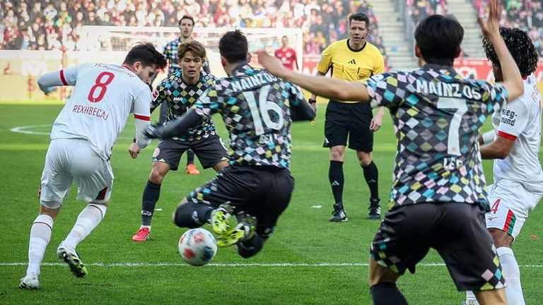 Der Mainzer Stefan Bell (Nr. 16) kommt im Augsburger Strafraum nach einem vermeintlichen Foul von Rexhbecaj (l.)  zu Fall. 