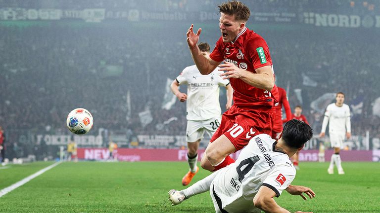 Gladbach-Verteidiger Kevin Diks (unten) grätscht im Hinspiel Köln-Stürmer Marius Bülter ab.